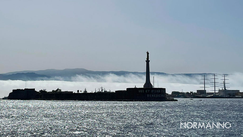 The Madonna della Lettera statue at the entrance of Messina harbour, standing against the fog